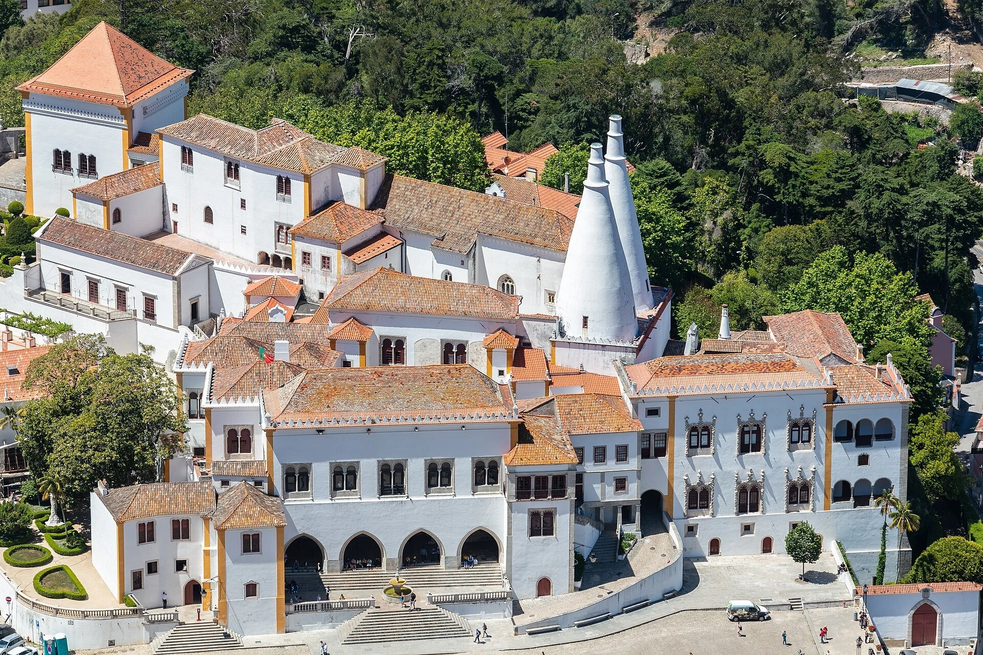 The white National Palace of Sintra, its red roofs and two conical chimneys above the historic town square